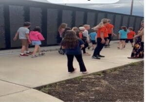The wall is reaching out to classroom of kids and two teachers